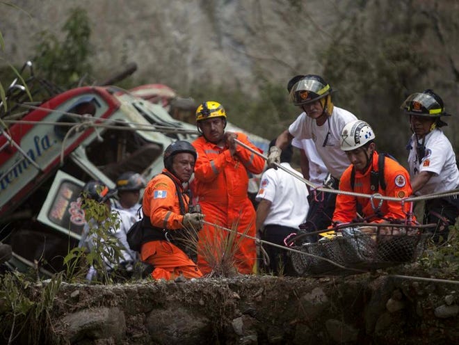 Rescuers remove the body  of a passenger after a bus plunged into a deep river canyon in San Martin Jilotepeque in northwest Guatemala on Monday. Dozens were killed and dozens more injured. A spokesman for the volunteer fire department in the area said about 90 people were aboard the bus, which had been headed for Guatemala City.
(LUIS SOTO | THE ASSOCIATED PRESS)