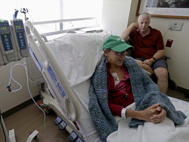 Bev Veals, accompanied by her husband Scott, undergoes chemotherapy treatment at Duke Cancer Center in Durham, N.C., recently. Coping with advanced cancer, Veals was in the hospital for chemo this summer when she got a call that her health plan was shutting down.
(GERRY BROOME | THE ASSOCIATED PRESS)