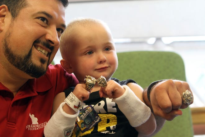 Former New England Patriots lineman Joe Andruzzi lets 3-year-old Logan Dimauro, of Coventry, try on his Super Bowl rings during his visit to Hasbro Children's Hospital.