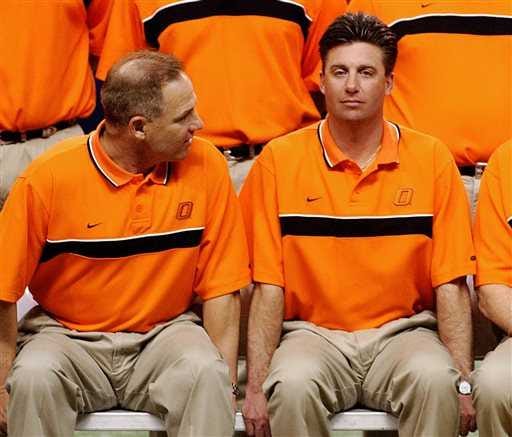 In this December 2004, file photo, Oklahoma State head coach Les Miles, left, and offensive coordinator Mike Gundy sit during photo day before the Alamo Bowl game in San Antonio, Texas. Boosters and assistant coaches at Oklahoma State handed out tens of thousands of dollars to players for at least a decade when Miles and later Gundy developed the Cowboys football program into a national power, according to a Sports Illustrated article released Tuesday.