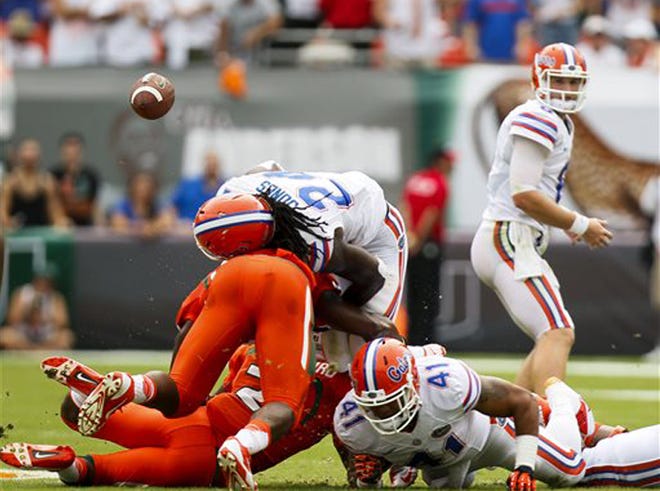Florida Gators running back Matt Jones (24) fumbles the ball against Miami during the first half of an NCAA college football game in Miami Gardens, Fla., Saturday, Sept. 7, 2013. Miami defeated Florida 21-16.