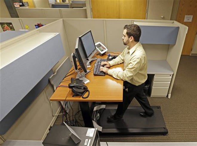Josh Baldonado, an administrative assistant at Brown & Brown Insurance, works at a treadmill desk in the firms offices in Carmel, Ind., Wednesday, Aug. 28, 2013. Workers sign up for 30 slots not he treadmills and have their phone and computer transferred to the workstations. Being glued to your desk is no longer an excuse for not having time to exercise as a growing number of Americans are standing, walking and even cycling their way through the work day at treadmill desks, standup desks or other moving work stations.