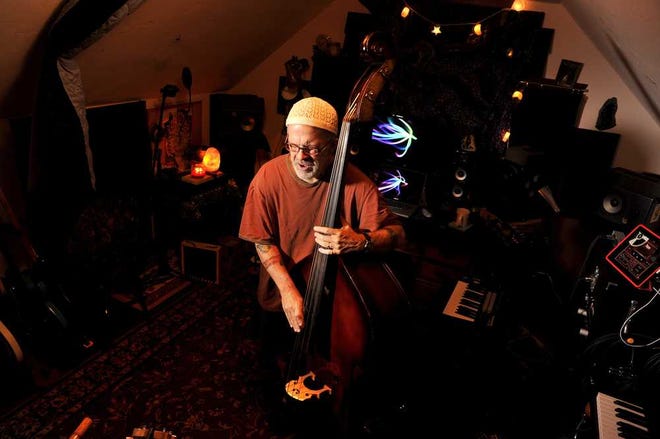 Photos by Bruce.Lipsky@jacksonville.com Musician Andy Ward King plucks the stand-up bass in his attic studio on Thursday in Jacksonville. King also writes a daily blog called, "My life with Parkinson's, the best life I've ever had."