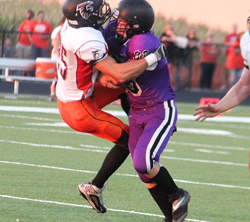 El Paso-Gridley running back Dustyn Brown lifts FCW defender Jon Hays during last week’s HOIC game in El Paso. The Titans have a tough task this week with a road game at Tri-Valley. FCW will host Lexington.