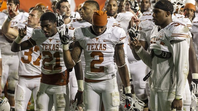 Texas players Duke Thomas (21), Mykkele Thompson (2) and Kendall Thompson (right) hold up their Hook ‘Em signs after last week’s 40-21 loss at BYU. Texas is no stranger to experiencing tough losses over the past three seasons — since 2010, the Longhorns have lost six games by at least two touchdowns; they are 3-3 in bounce-back games immediately following those losses.