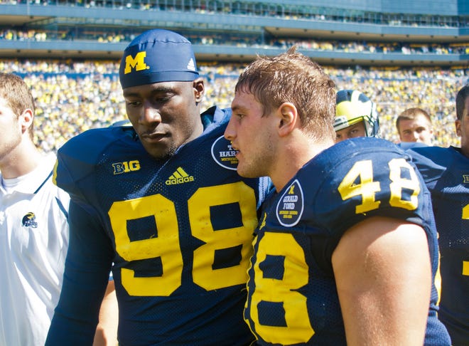 Michigan quarterback Devin Gardner (98) has words with linebacker Desmond Morgan (48) after an NCAA college football game against Akrain in Ann Arbor, Mich., Saturday, Sept. 14, 2013. Michigan won 28-24. Gardner had 3 interceptions and 1 lost fumble. (AP Photo/Tony Ding)