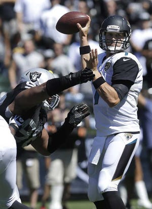 Jeff Chiu Associated Press Jaguars quarterback Chad Henne tries to pass as Raiders defensive tackle Vance Walker applies pressure during the first quarter Sunday in Oakland, Calif.