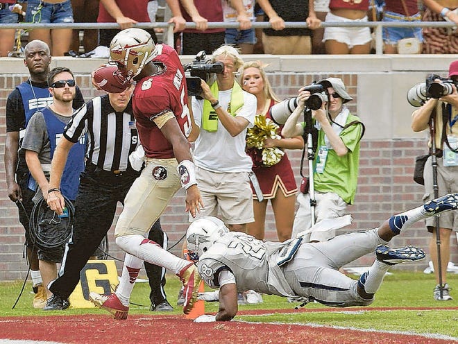 Florida State's Jameis Winston (5) scores despite the diving tackle attempt of Nevada's Elijah Mitchell in the third quarter of an NCAA college football game on Saturday, Sept. 14, 2013, in Tallahassee, Fla. Florida State won the game 62-7. (AP Photo/Steve Cannon)