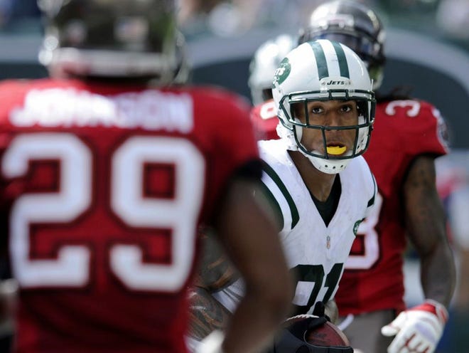 In this Sunday, Sept. 8, 2013, photol, New York Jets tight end Kellen Winslow, center, holds on to the ball after scoring on a 7-yard touchdown pass from quarterback Geno Smith against the Tampa Bay Buccaneers during an NFL football game in East Rutherford, N.J. The former Pro Bowl tight end had a terrific debut with the Jets on Sunday, catching a team-leading seven passes for 79 yards and a touchdown in the 18-17 win over Tampa Bay. (AP Photo/Bill Kostroun)