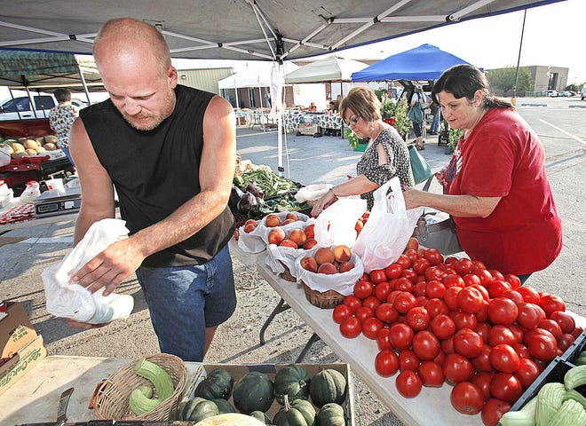 Randy Peters with Dennis Farm in Blanchard, sells produce to Peggy Lukezic and Karen Delapaz as they shop at the Norman Farmer's Market on Wednesday, August 24, 2011, in Norman, Okla.  Photo by Steve Sisney, The Oklahoman ORG XMIT: KOD
