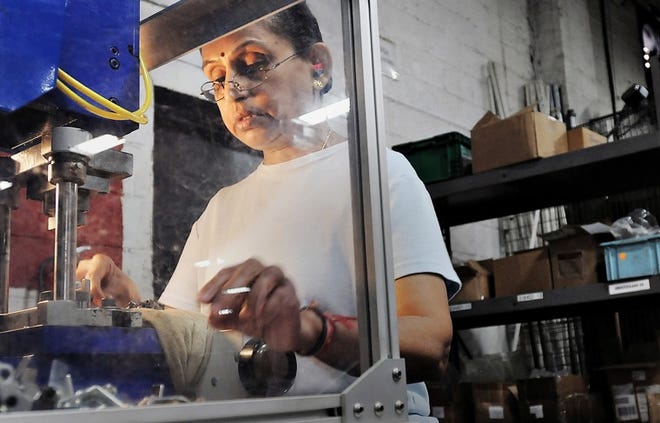 Bharati Patel uses a stamp machine to manufacture automotive parts at Spalding Automotive in Bensalem.