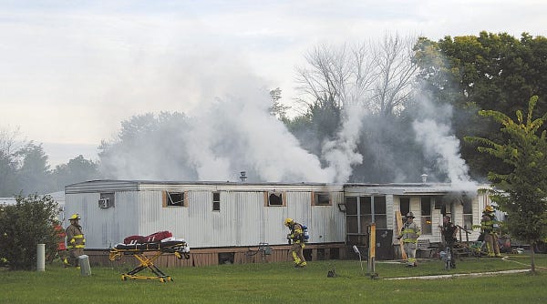 Firefighters extinguish the mobile-home fire in Tiffin, Ohio, in which six people died.