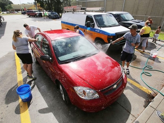 Volunteers wash cars during a car wash fundraiser for Rebecca Ann Sedwick at the 7-11 on U.S. 98 and Daughtery Road in Lakeland Sunday. The 12-year-old Lakeland girl was found dead early Tuesday morning at an abandoned cement business. Rebecca committed suicide after being bullied for one and half years. Organizers say they will hold another benefit carwash next Saturday form 9 a.m. to 3 p.m. at the same location. Funds raised will go to funeral expenses.