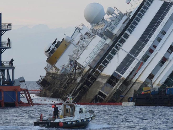 The Costa Concordia ship lies on its side on the Tuscan Island of Giglio, Italy, on Monday. In an unprecedented maritime salvage operation, engineers on Monday gingerly wrestled the hull of the shipwrecked Costa Concordia off the Italian reef where the cruise ship has been stuck since January 2012. 
(ANDREW MEDICHINI | THE ASSOCIATED PRESS)