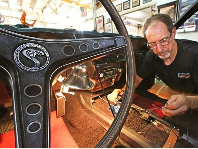 Jeff Brekke, Lloyd's Auto Restorations, works on installing wiring in the console of a 1969 Shelby Mustang GT500 at his shop in Bartow. The Mustang is undergoing final stages of reassembly.