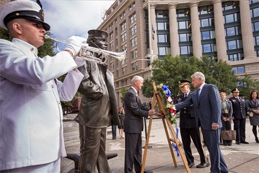 Defense Secretary Chuck Hagel, right, and Joint Chiefs Chairman Gen. Martin Dempsey, second from right, present a wreath at the Navy Memorial in Washington Tuesday to remember the victims of Monday's deadly shooting at the Washington Navy Yard.