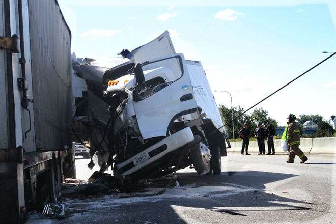 Rhode Island State Troopers and firefighters tend to an accident scene on Route 95 north in Providence after a truck collided with a tractor-trailer that had pulled over near the Point Street exit after having brake trouble.