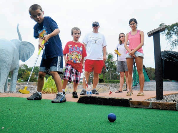 Mason Timberlake putts while his family watches at Oak Island Jungle Golf at 6321 E. Oak Island Drive in Oak Island.