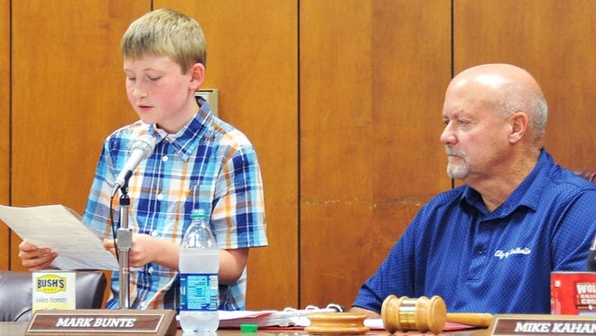 Bradley Boatright, a 5th-grade student at Smithville Elementary School, gives a speech about the character trait of “honesty” at the Smithville City Council meeting Monday night. Mayor Mark Bunte looks on. TERRY HAGERTY/AUSTIN COMMUNITY NEWSPAPERS