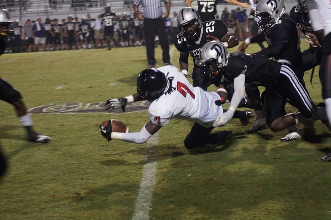 DHS senior receiver Leondre James gets tackled by Dutchtown defenders in the team’s loss Friday night.