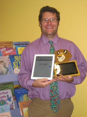 Director Chip Schrader displays the new tablets that are available for patrons to use at the Springvale Public Library.