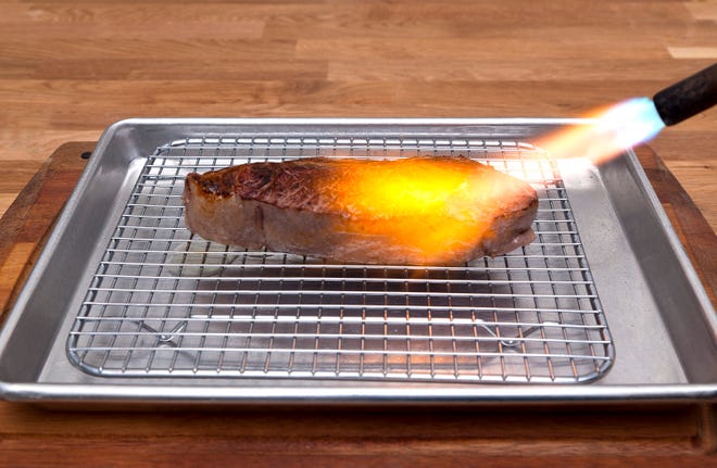 This undated image provided by Modernist Cuisine shows a sous vide-cooked steak seared with a torch.