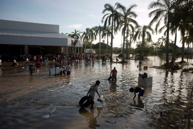 People wade through waist-high water in a store's parking, looking for valuables, south of Acapulco, in Punta Diamante, Mexico, Wednesday, Sept. 18, 2013. Mexico was hit by the one-two punch of twin storms over the weekend, and the storm that soaked Acapulco on Sunday - Manuel -re-formed into a tropical storm Wednesday, threatening to bring more flooding to the country's northern coast. With roads blocked by landslides, rockslides, floods and collapsed bridges, Acapulco was cut off from road transport. (AP Photo/Eduardo Verdugo) 
 A car lays buried in mud after flooding triggered by Tropical Storm Manuel as residents try to clean up their neighborhood in Chilpancingo, Mexico, Thursday, Sept. 19, 2013. Manuel, the same storm that devastated Acapulco, gained hurricane force and rolled into the northern state of Sinaloa on Thursday before starting to weaken. (AP Photo/Alejandrino Gonzalez)