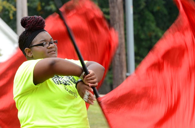BRIAN D. SANDERFORD TIMES RECORD Destiny Watson twirls a flag as the Kimmons Junior High School Marching Band plays on Wednesday, Sept. 18, 2013. The Red Raiders were rehearsing for tonights performance during the Kimmons - Ramsey football game.