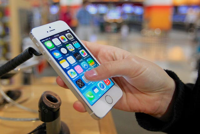 A customer examines a new iPhone 5s at the Nebraska Furniture Mart in Omaha, Neb., on Friday, Sept. 20, 2013, the day the new iPhone 5c and 5s models go on sale. (AP Photo/Nati Harnik)