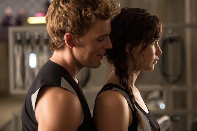 This film image released by Lionsgate shows Sam Claflin, left, and Jennifer Lawrence in a scene from "The Hunger Games: Catching Fire." (AP Photo/Lionsgate, Murray Close)