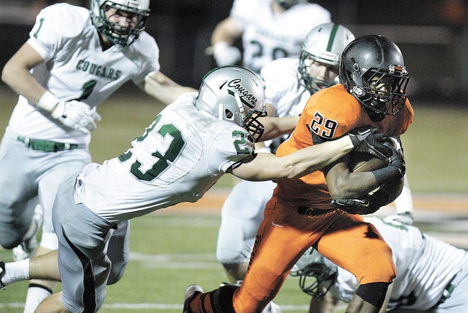 Massillon running back Lyron Wilson breaks the tackle of Lake Catholic’s Matt Ludwig for a touchdown during the second quarter of Friday’s 35-6 victory.