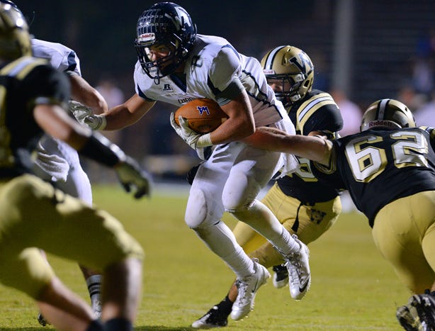 Western Alamance running back Donovan Apple powers through the Williams High School defense with Corey Sartin, rear, trying to slow him down and Stuart Powell, right, attempting to make a stop.