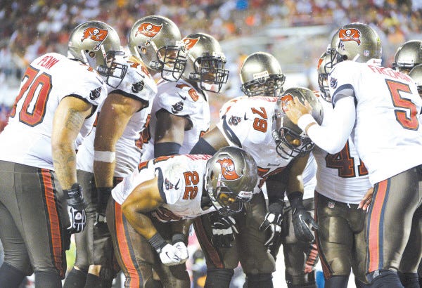 ADVANCE FOR WEEKEND EDITIONS, SEPT. 21-22 - FILE - In this Sunday, Sept. 15, 2013, file photo, Tampa Bay Buccaneers quarterback Josh Freeman (5) calls a play in the huddle during the second half of an NFL football game against the New Orleans Saints in Tampa, Fla. Tampa Bay can't close out games, losing twice already on last-second field goals. New England can't seem to find the magic on offense, yet has pulled out two close victories. When the Bucs visit the Patriots on Sunday, it will be a study in contrasts. (AP Photo/Phelan M. Ebenhack, File) ORG XMIT: NY183