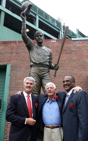 Baseball Hall of Famer Carl Yastrzemski, center, stands with former Boston Red Sox’s Dwight Evans, left, and Hall of Famer Jim Rice, right, Sunday during a ceremony held to unveil a statue of Yastrzemski at Fenway Park in Boston.