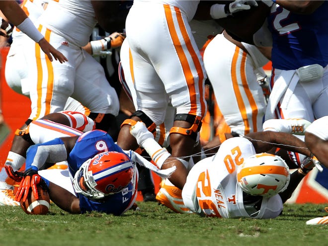 Florida defensive end Dante Fowler Jr. (6) recovers a fumble after hitting Tennessee running back Rajion Neal (20) during the first half at Ben Hill Griffin Stadium on Saturday. Florida defeated Tennessee 31-17.