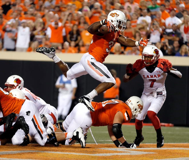 Oklahoma State's Jeremy Smith (31) leaps into the end zone for a touchdown during a college football game between the Oklahoma State University Cowboys (OSU) and the Lamar University Cardinals at Boone Pickens Stadium in Stillwater, Okla., Saturday, Sept. 14, 2013. Photo by Sarah Phipps, The Oklahoman