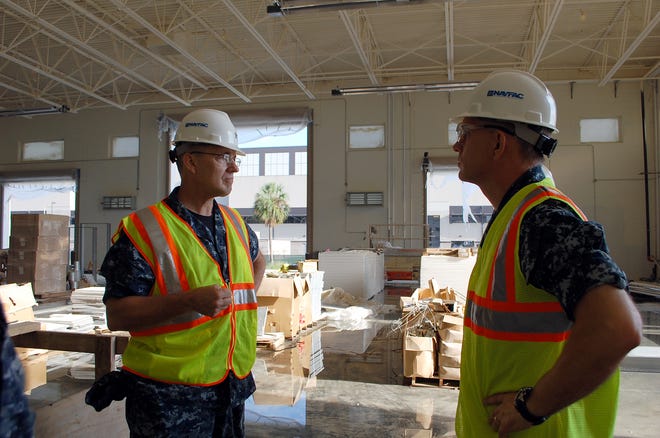 Commander, Navy Region Southeast Rear Adm. Rick Williamson (left) and NAS Jax Commanding Officer Capt. Roy Undersander discuss the future of the new MQ-4C Triton Unmanned Aerial System and P-8A Maintenance Training Facility during the admiral's tour of the station on Sept. 19.