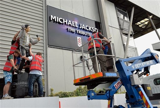 A group of stonemasons remove the statue of US performer Michael Jackson, that was erected by previous owner Mohammed al Fayed, on the north west corner of Fulham Football Club, in London, Wednesday Sept. 25, 2013. The controversial Michael Jackson statue which has stood outside Fulham's Craven Cottage ground for over two years was removed on Wednesday.
