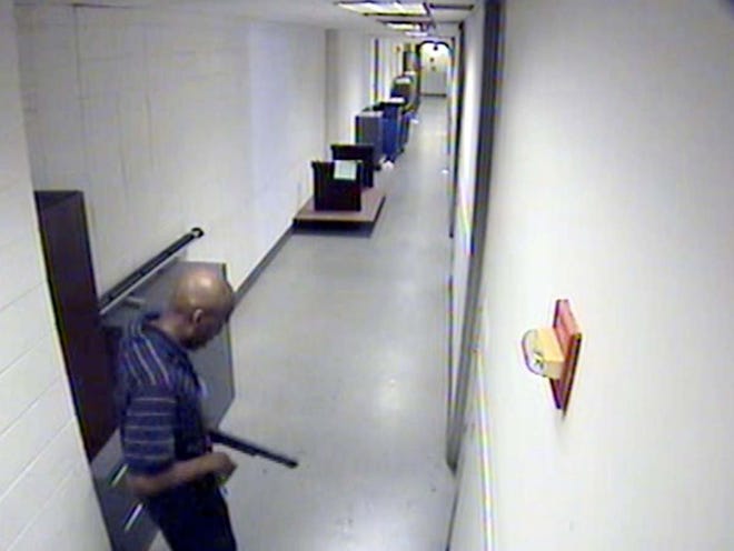 A video image, provided by the FBI, shows Aaron Alexis moving through the hallways of Building #197 at the Washington Navy Yard on Sept. 16, carrying a Remington 870 shotgun. Alexis, a 34-year-old former Navy reservist and IT contractor, shot and killed 12 people inside a Navy Yard building before being killed in a shootout with police.
 (FBI)
