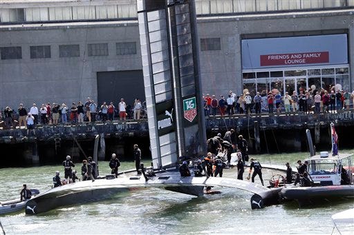 Oracle Team USA members board their catamaran as fans watch before the 19th race of the America's Cup sailing event against Emirates Team New Zealand on Wednesday, in San Francisco.