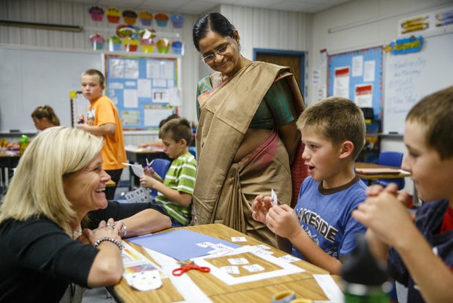 Lalitha Kannamani, the principal of Bishop Pereira Memorial School in Karamoodu, a village in the state of Kerala on India's southwestern coast, observes Principle Elizabeth Gregurich talking with Will Edwards, 10, about his math project in Rae Long's fifth grade class at Glenwood Intermediate School, Tuesday, Sept. 24, 2013, Chatham, Ill.