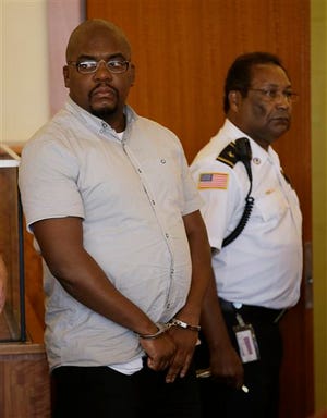 Ernest Wallace, left, an associate of former New England Patriots tight end Aaron Hernandez, looks toward his attorneys as he appears in Bristol Superior Court for a bail hearing on a charge of accessory to murder after the fact in the death of semi-professional football player Odin Lloyd in Fall River, Mass., Thursday, Sept. 26, 2013. A cash bail of $500,000 was set for Wallace.
