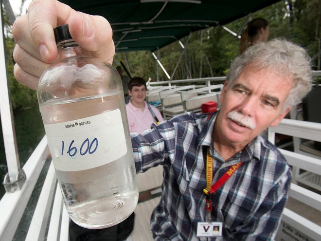 Vanguard High School IB chemistry teacher John Hare shows a full bottle of water collected at the 1,600-meter site from the main boil along the Silver River Tuesday morning during a monthly sampling.