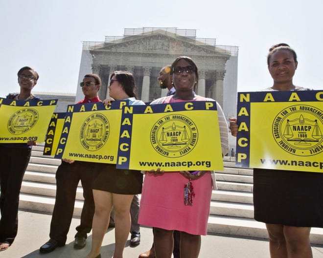 This June 25 file photo shows representatives from the NAACP Legal Defense Fund standing outside the Supreme Court in Washington, awaiting a decision in Shelby County v. Holder, a voting rights case in Alabama. Newly emboldened by a Supreme Court decision that struck down the heart of the Voting Rights Act, a growing number of Republican-led states are moving aggressively to tighten voting rules, prompting lawsuits from the Obama administration and voting rights activists who say the measures disproportionately impact minorities.