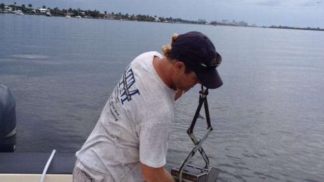 A technician with Applied Technology & Management takes a sediment sample from the Lake Worth Lagoon on Tuesday. The company finished field investigations last week that will help determine the feasibility and cost of connecting private docks to a secondary channel leading to the main Intracoastal Waterway channel.