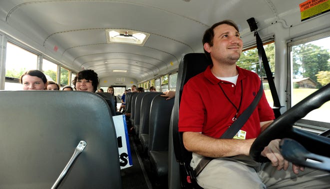 Bus driver Brandon Talbott looks in his overhead mirror as students from the Attalla City and Etowah County school systems transfer between buses Thursday at Noccalula Falls in Gadsden. The transfer allows buses to run more concise bus routes on Lookout Mountain, where students can attend either Attalla or Etowah County schools.