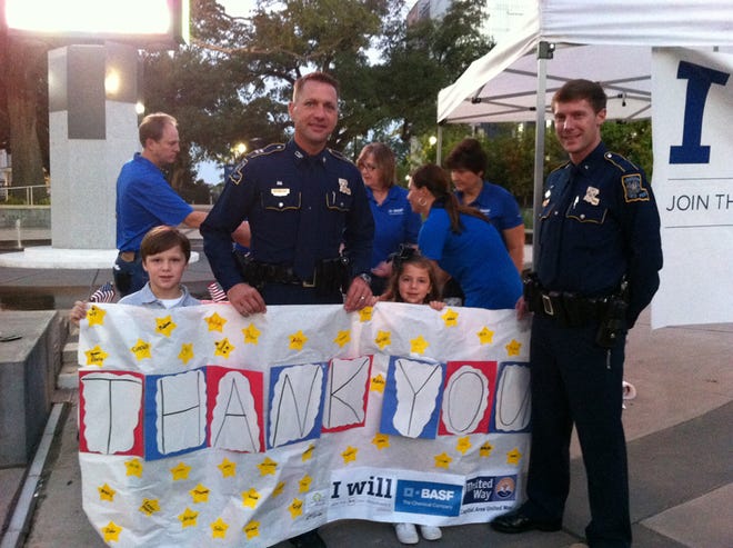Students from Holy Family School present a thank-you banner to representatives from Louisiana State Police on Wednesday, September 11th as part of the Capital Area United Way and BASF's 9/11 Day of Service and Remembrance.