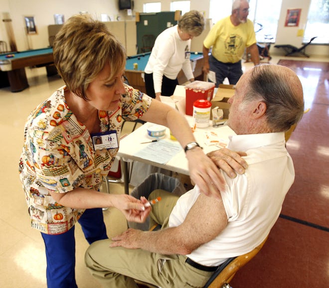 Health department registered nurse Vicki Edwards gives a flu shot to Leroy Dyer. (Star file photo)
