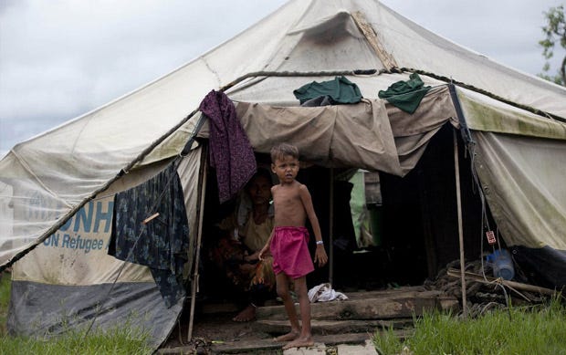 A displaced Muslim girl stands in front of a tent at Nga Chaung Refugee Camp in Pauktaw, Rakhine state, Myanmar.