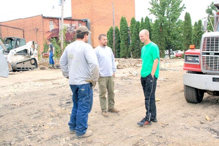 Scott Post and David Harker, co-owners of Harker Excavating, talk with Jeremy Gump of Inquire Partners about their finds under the demolished former Moose Lodge building.